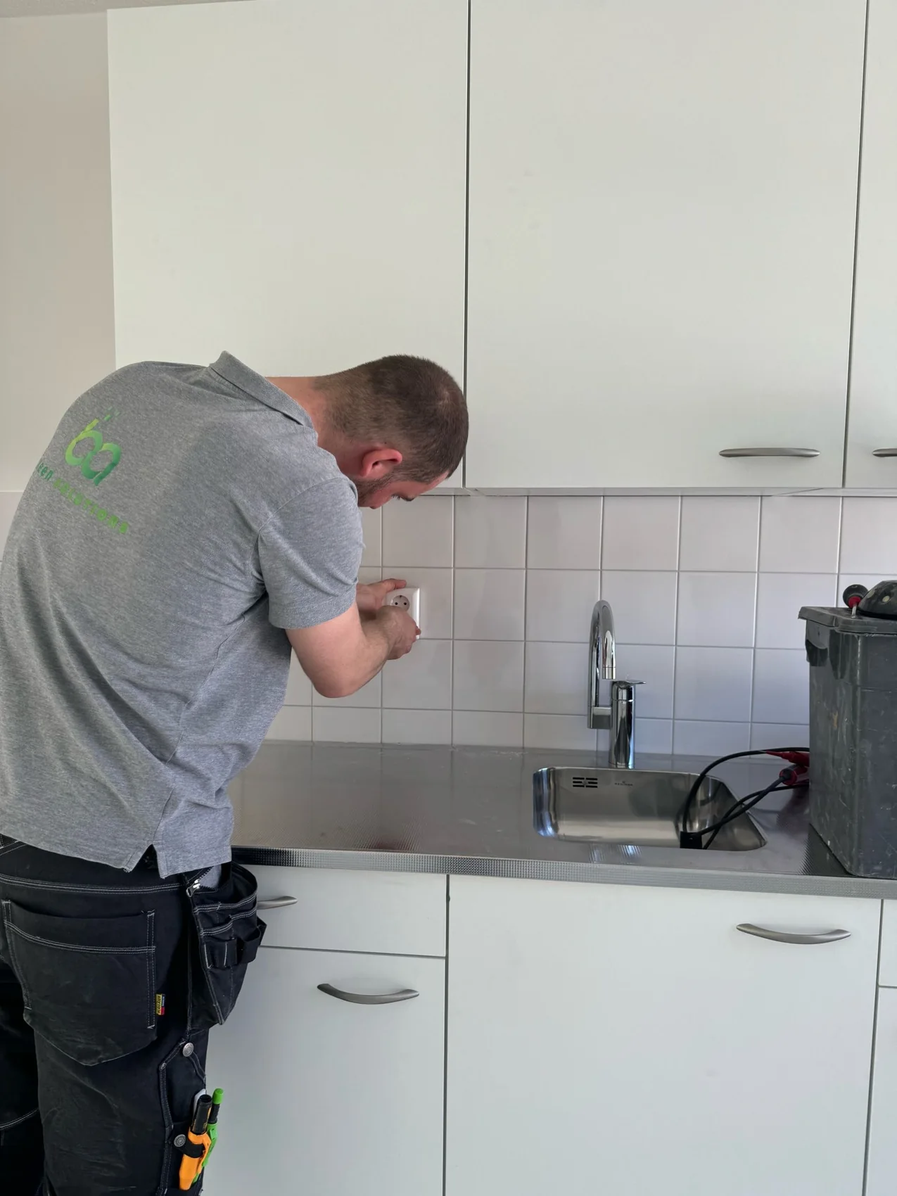 B&A monteur voert werkzaamheden uit aan een wandcontactdoos in een keuken